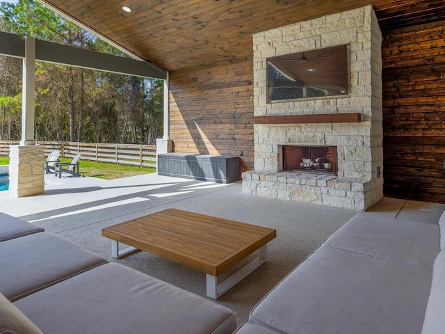 living area featuring wooden ceiling, an outdoor stone fireplace, and high vaulted ceiling