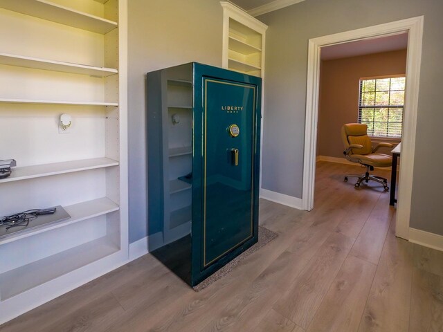 interior space with built in shelves, wood finished floors, and baseboards