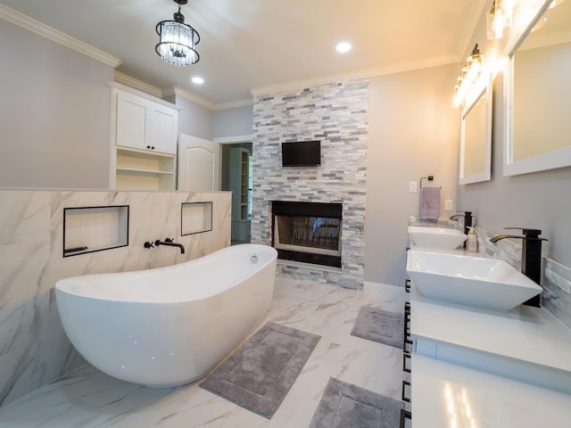 full bathroom featuring marble finish floor, a fireplace, a soaking tub, ornamental molding, and a sink