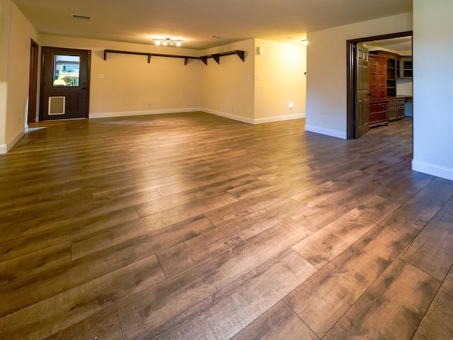 interior space featuring dark wood-type flooring, visible vents, and baseboards