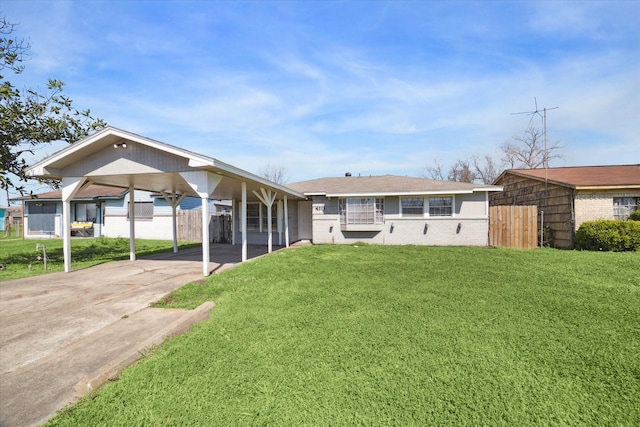 view of front of home featuring a carport, brick siding, a front yard, and fence