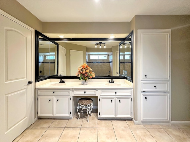 full bathroom featuring double vanity, tiled shower, a sink, and tile patterned floors