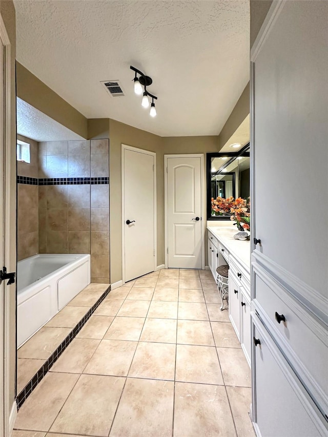 full bath featuring a bathtub, visible vents, a textured ceiling, vanity, and tile patterned floors