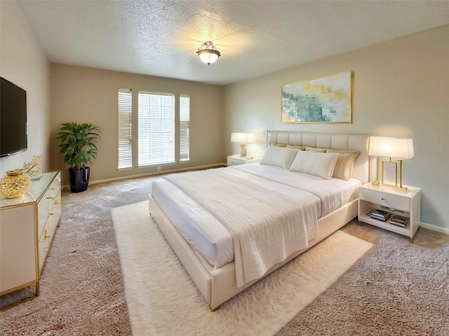 bedroom featuring a textured ceiling, baseboards, and light colored carpet