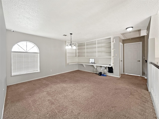 unfurnished living room with attic access, visible vents, baseboards, carpet, and a textured ceiling