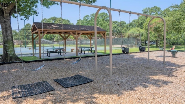 view of home's community featuring a tennis court and fence