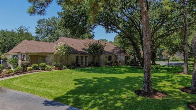ranch-style home with fence and a front lawn