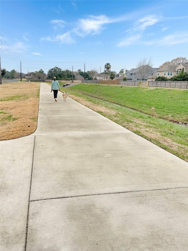 surrounding community with fence and a lawn