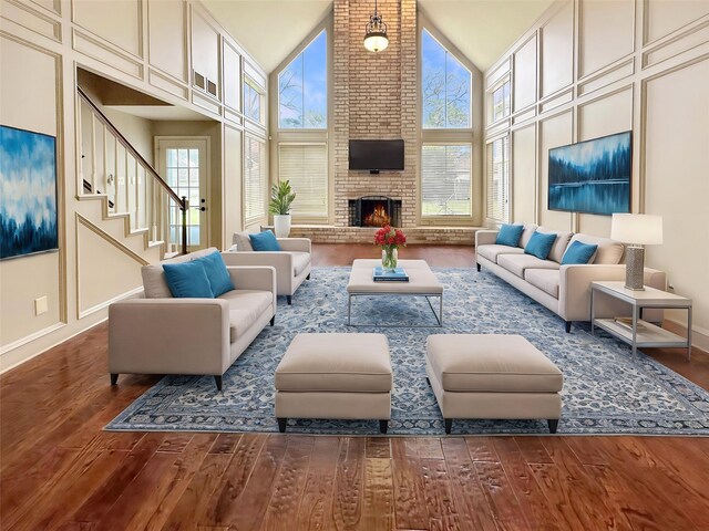 17439 Fairway Oaks Dr, Spring, TX 77379 - living area featuring wood finished floors, high vaulted ceiling, a fireplace, stairway, and baseboards