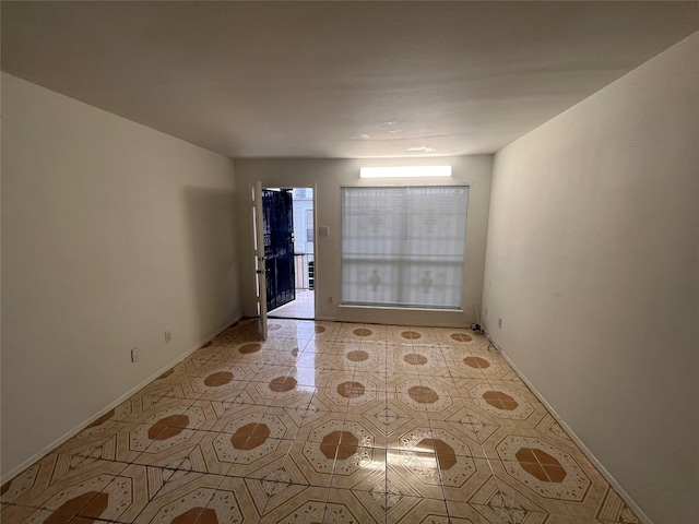 spare room with light tile patterned flooring and baseboards