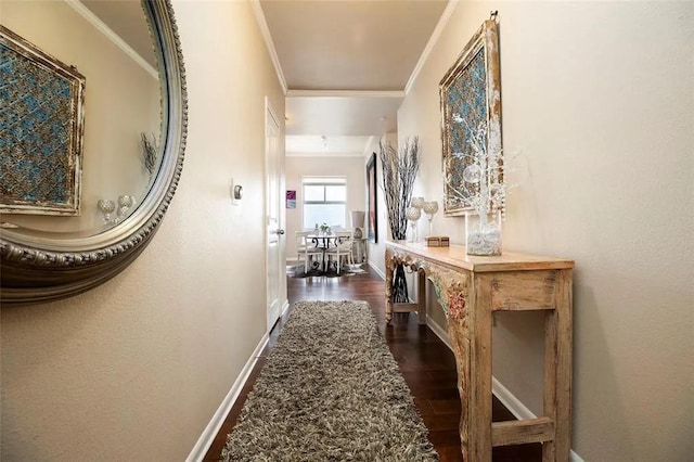 hall featuring baseboards, ornamental molding, and dark wood-style flooring