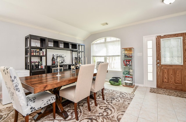 dining space featuring light tile patterned floors, baseboards, visible vents, vaulted ceiling, and crown molding