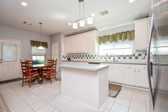 kitchen featuring light countertops, stainless steel fridge, and white cabinets