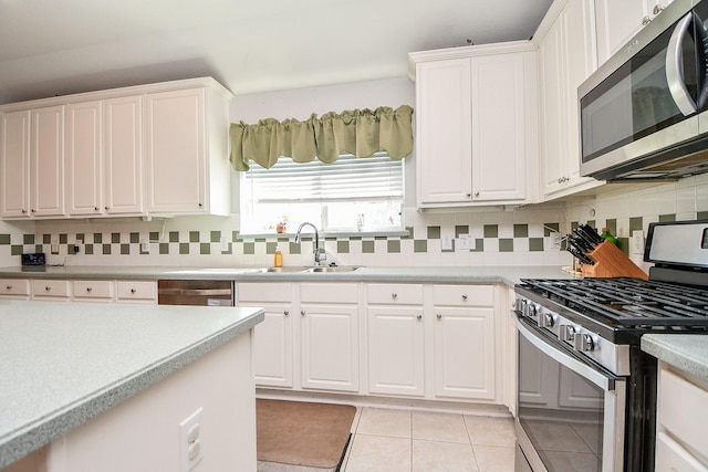 kitchen featuring a sink, white cabinetry, stainless steel appliances, and light countertops