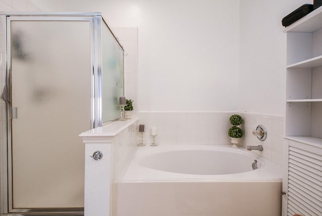 full bathroom featuring a shower stall and a bath