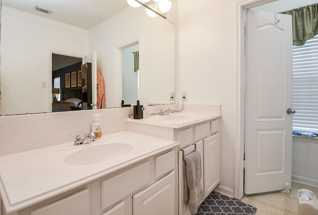 bathroom featuring two vanities, visible vents, a sink, and baseboards