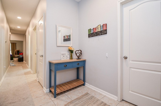 hallway featuring light tile patterned floors, baseboards, and recessed lighting