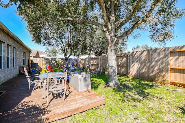 view of yard with outdoor dining space, a fenced backyard, and a wooden deck