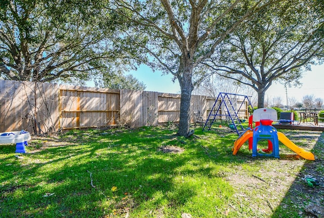 view of yard featuring a fenced backyard and a playground