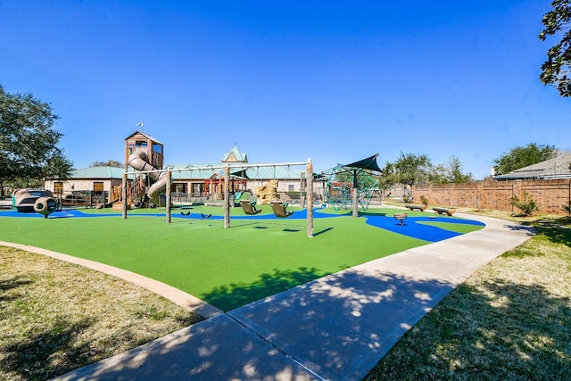 community play area featuring fence and a lawn