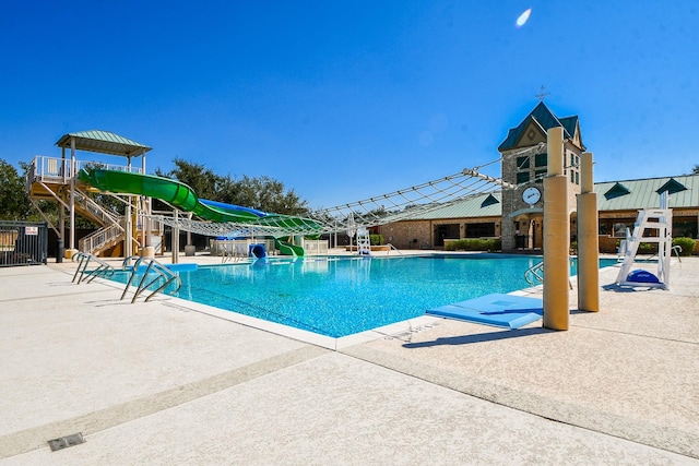 pool with a water slide and a patio area