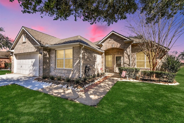 ranch-style home featuring brick siding, a shingled roof, concrete driveway, an attached garage, and a front lawn