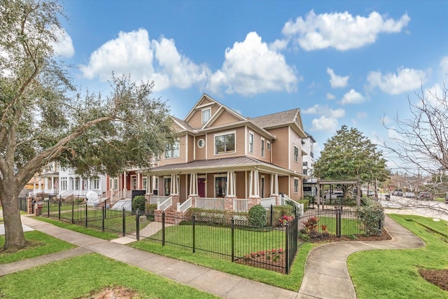 view of front of house featuring covered porch, a fenced front yard, and a front lawn