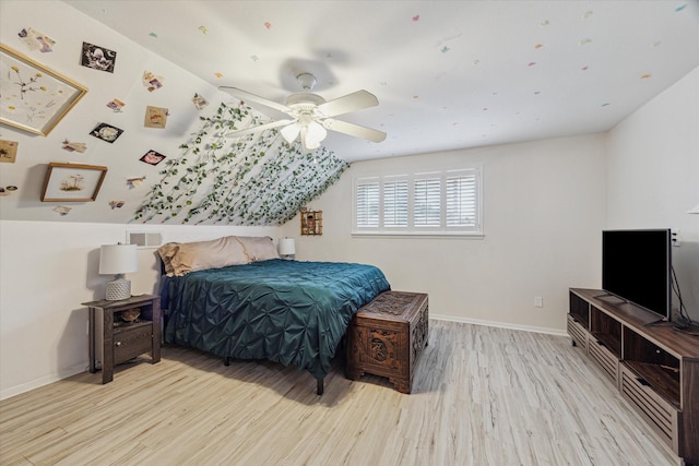 bedroom featuring light wood finished floors, ceiling fan, baseboards, and vaulted ceiling