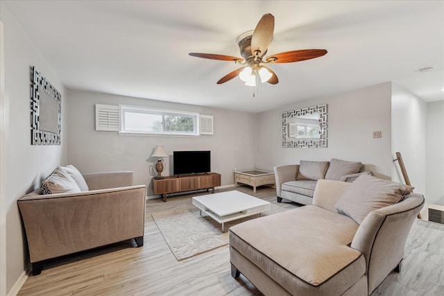 living area with ceiling fan, light wood-style flooring, and baseboards