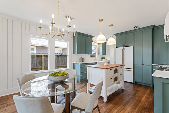 kitchen with high end white refrigerator, visible vents, butcher block counters, dark wood-style flooring, and pendant lighting