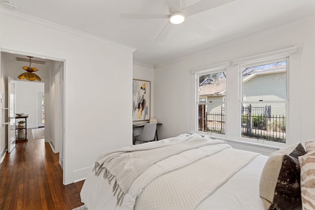 bedroom with ornamental molding, dark wood finished floors, and a ceiling fan