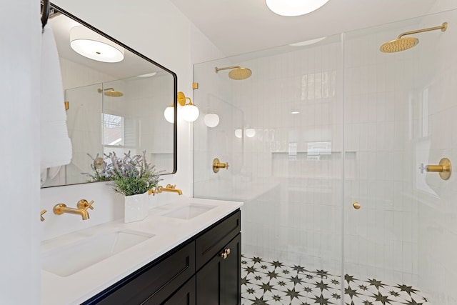 bathroom featuring a sink, a tile shower, and double vanity