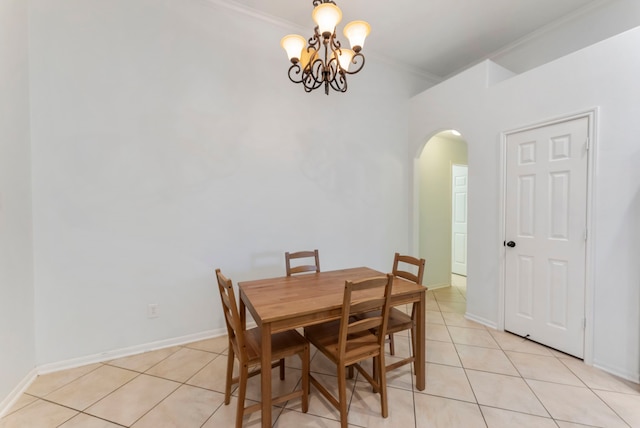 dining room with arched walkways, light tile patterned floors, ornamental molding, and baseboards