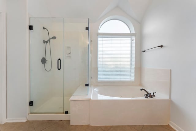 bathroom with a stall shower, vaulted ceiling, a garden tub, and tile patterned floors