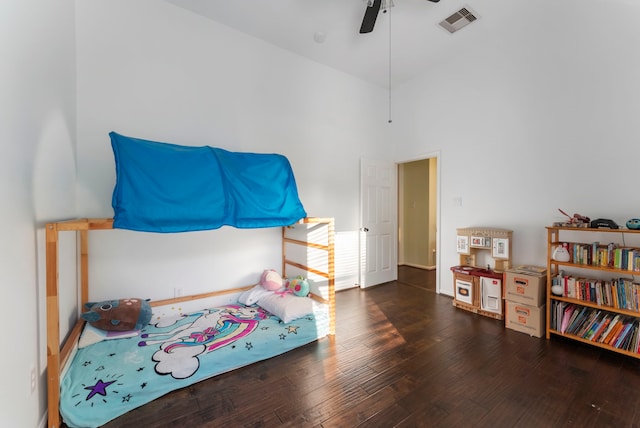 bedroom with visible vents, a towering ceiling, dark wood-type flooring, a ceiling fan, and baseboards