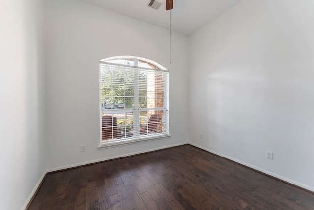 spare room featuring a ceiling fan, dark wood finished floors, visible vents, and baseboards