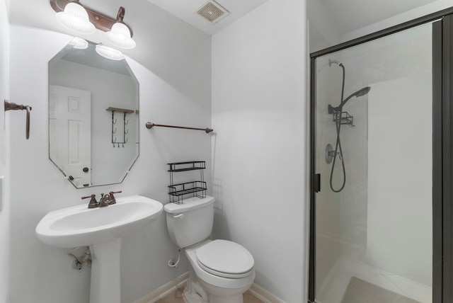 full bathroom featuring toilet, a sink, visible vents, baseboards, and a shower stall