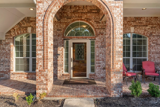 view of exterior entry featuring brick siding