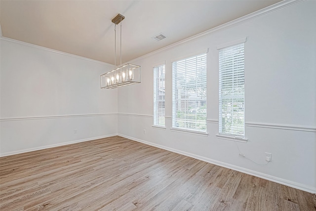 spare room with crown molding, visible vents, wood finished floors, a chandelier, and baseboards