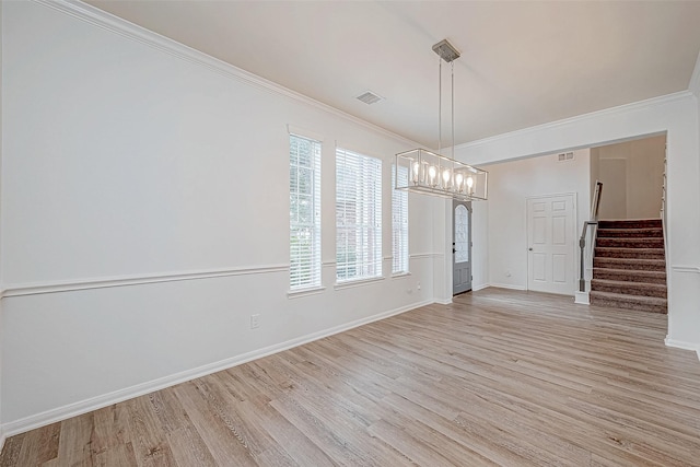 unfurnished dining area with light wood finished floors, stairs, and crown molding