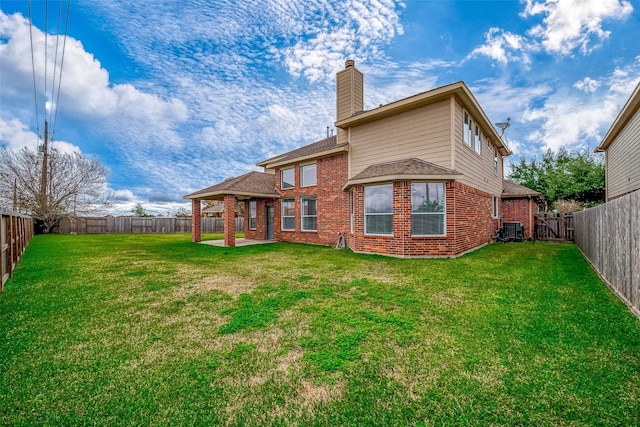 back of property with a chimney, a lawn, and brick siding