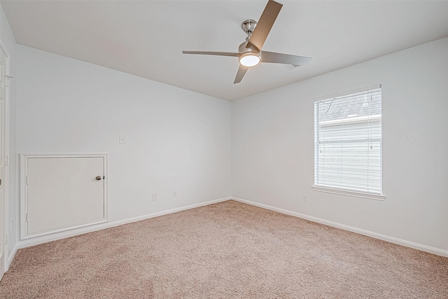 spare room with ceiling fan, carpet, and baseboards