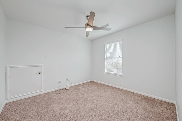 carpeted empty room featuring visible vents, baseboards, and a ceiling fan