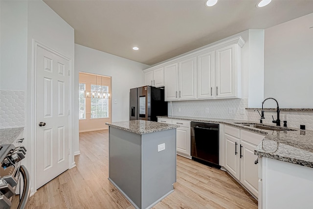 kitchen featuring white cabinets, dishwasher, stainless steel fridge with ice dispenser, gas range, and a sink