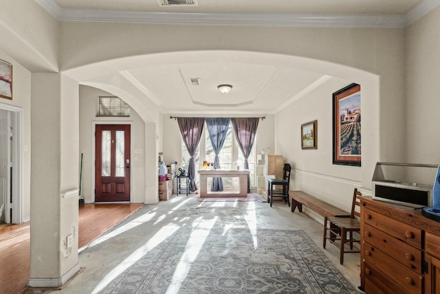 foyer entrance featuring arched walkways, a wealth of natural light, and ornamental molding