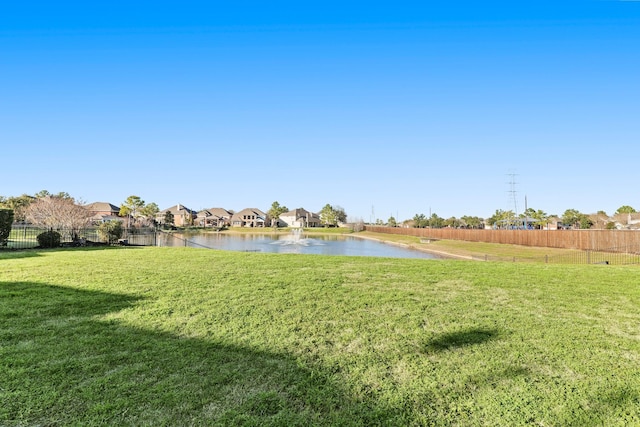 view of yard with a water view and fence