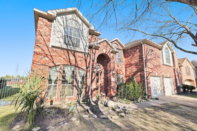 view of front of house with driveway, a garage, fence, and brick siding