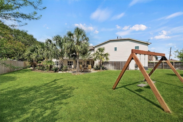 rear view of house featuring a playground, a lawn, and a fenced backyard