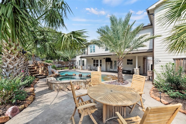 view of patio with a fenced in pool, fence, ceiling fan, and an in ground hot tub