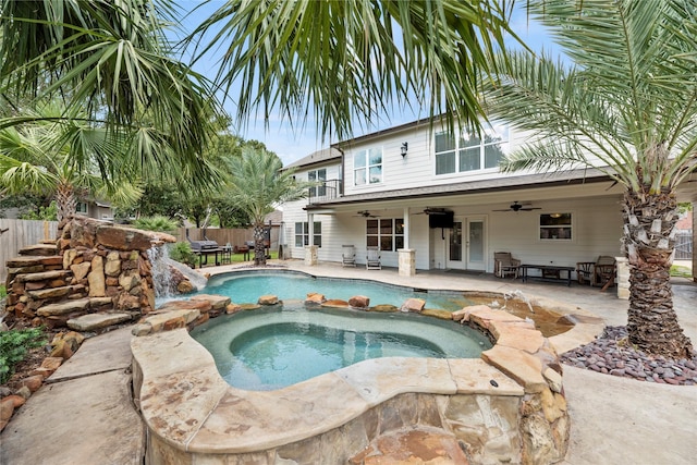 view of swimming pool featuring a pool with connected hot tub, a patio area, ceiling fan, and fence